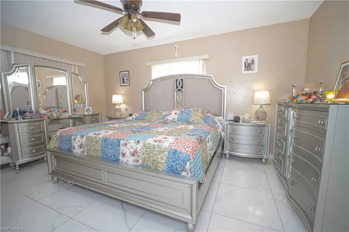Bedroom with light marble finish flooring and a ceiling fan
