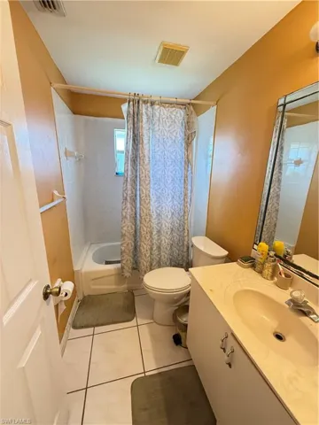 Full bathroom featuring shower / tub combo, vanity, and light tile patterned floors