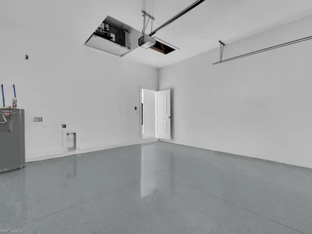 Garage featuring a garage door opener and water heater