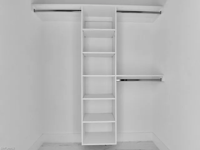 Walk in closet with tile flooring