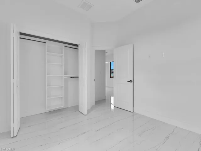 Unfurnished bedroom featuring a closet and light tile flooring