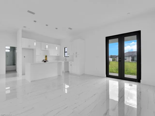 Unfurnished living room with french doors and light tile flooring