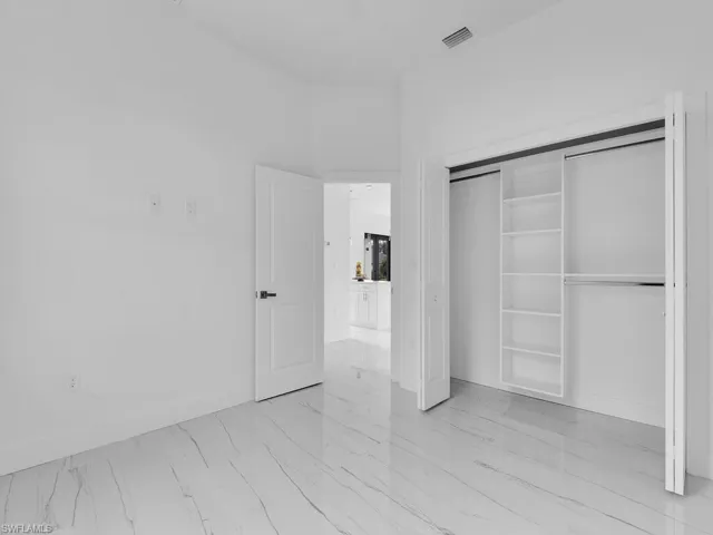 Unfurnished bedroom featuring a closet and light tile floors