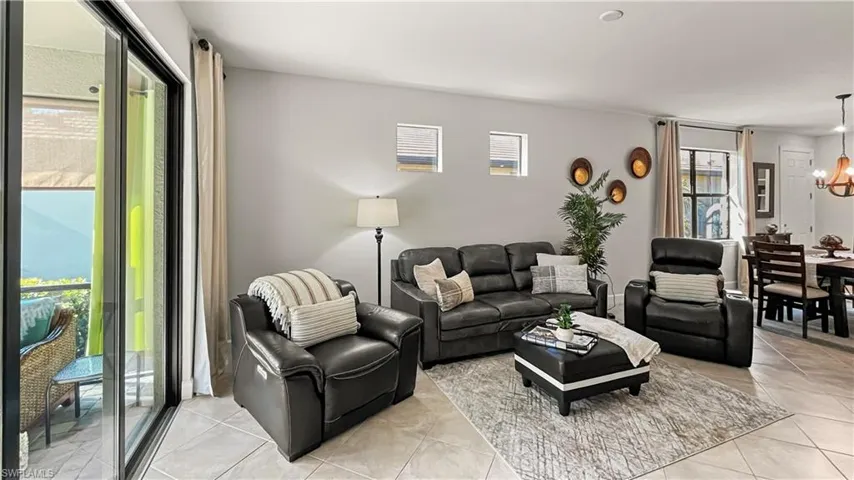 Living room featuring a notable chandelier, a wealth of natural light, and light tile patterned floors
