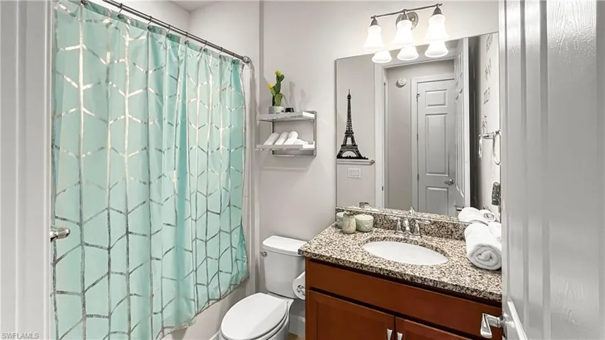 Full bathroom with shower / tub combo with curtain, vanity, and toilet
