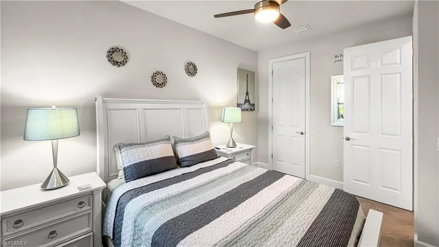 Carpeted bedroom featuring ceiling fan