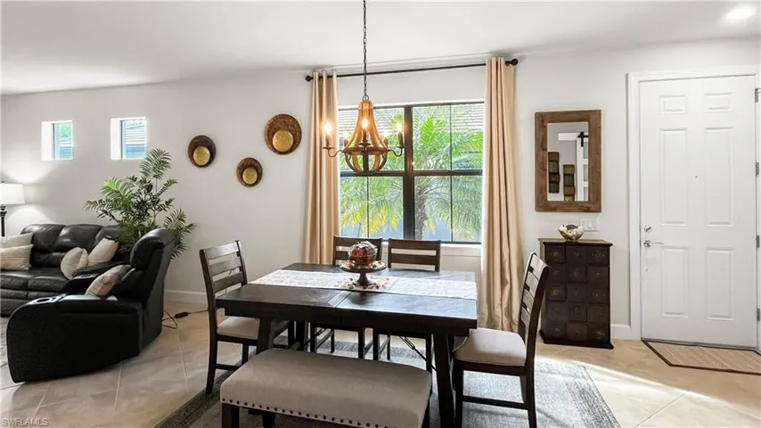 Tiled dining area featuring an inviting chandelier