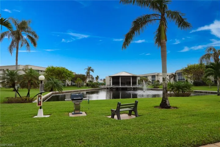 View of community featuring a water view, a lawn, and a residential view
