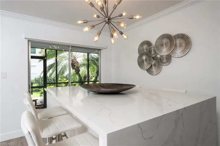 Dining space with a chandelier, ornamental molding, and wood finished floors