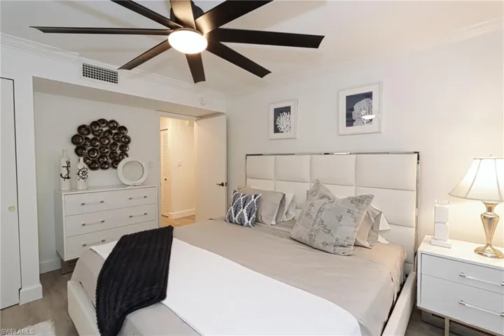 Bedroom featuring crown molding, light wood-style floors, ceiling fan, and baseboards