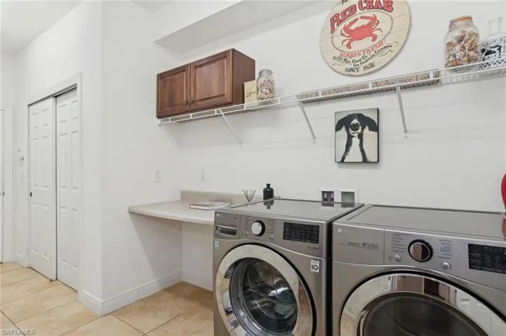Clothes washing area featuring light tile patterned flooring and independent washer and dryer