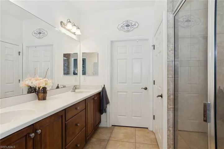 Bathroom with vanity, tile patterned floors, and a shower with shower door