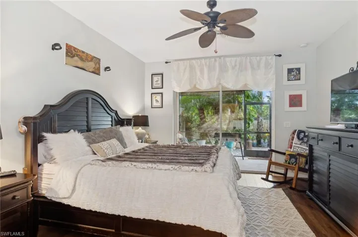 Bedroom with ceiling fan, dark hardwood / wood-style flooring, and access to exterior