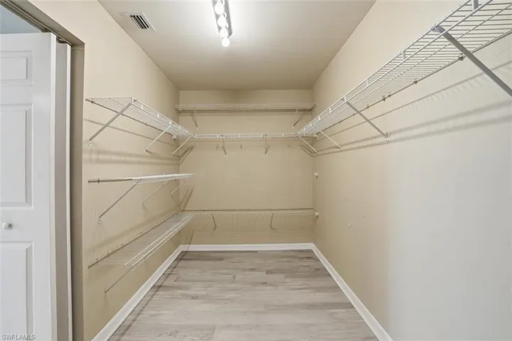 Spacious closet featuring light wood-style flooring