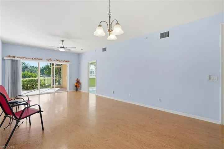 Unfurnished room featuring light wood finished floors, a chandelier, and ceiling fan