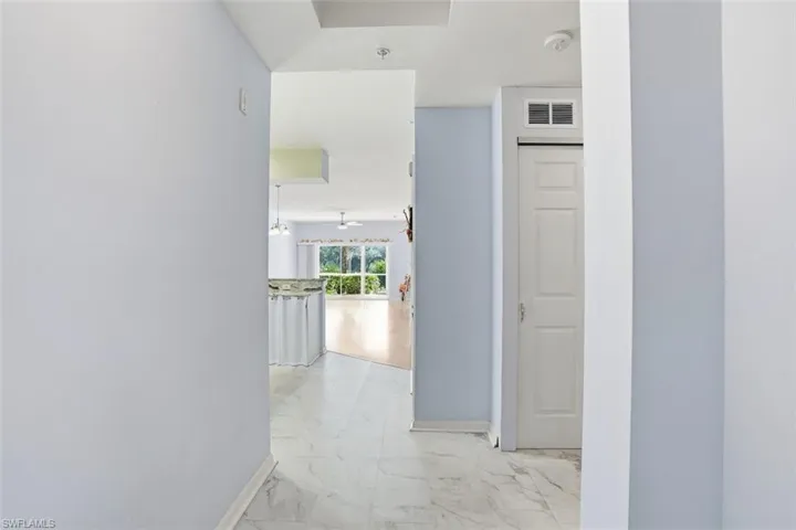 Hall featuring light marble finish flooring and baseboards