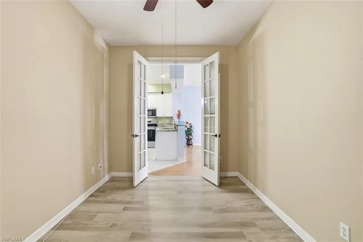 Unfurnished dining area with french doors, light wood finished floors, and ceiling fan