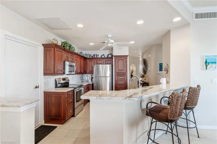 Kitchen with visible vents, decorative backsplash, appliances with stainless steel finishes, a kitchen breakfast bar, and a peninsula