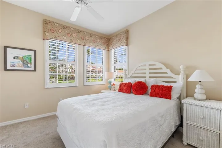 Carpeted bedroom featuring ceiling fan and baseboards