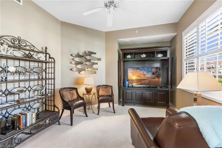 Sitting room featuring ceiling fan, carpet, and baseboards
