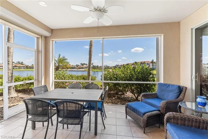 Sunroom with a ceiling fan and a water view