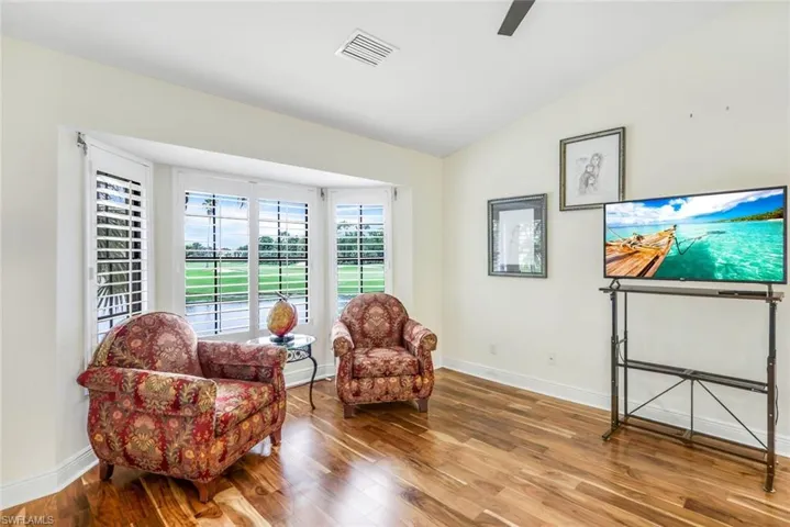 Primary bedroom featuring ceiling fan, high vaulted ceiling, and Acacia wood floors