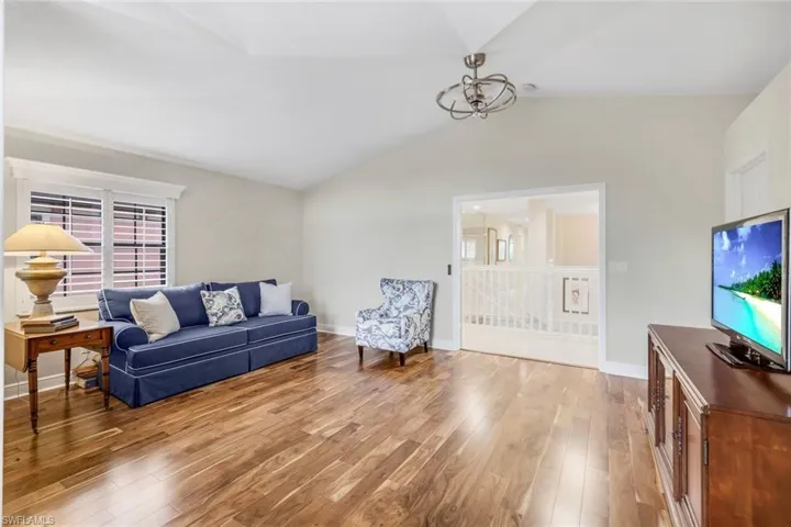 Guest bedroom featuring vaulted ceiling and wood flooring