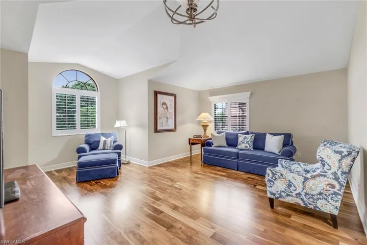 Guest bedroom featuring vaulted ceiling and wood flooring