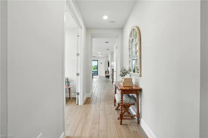 Corridor featuring light wood finished floors and recessed lighting