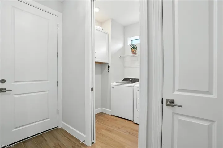 Laundry room featuring light wood-style floors and washer and clothes dryer
