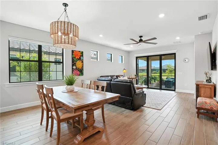 Dining area featuring light wood-type flooring, ceiling fan, a chandelier, and recessed lighting