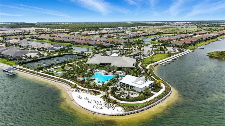 Aerial view of residential area featuring a large body of water and a pool