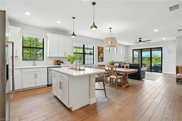 Kitchen with stainless steel dishwasher, open floor plan, light countertops, healthy amount of natural light, and recessed lighting