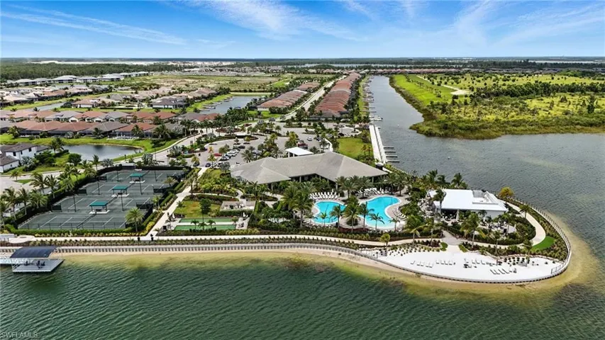 Aerial view of residential area with a nearby body of water and a pool area