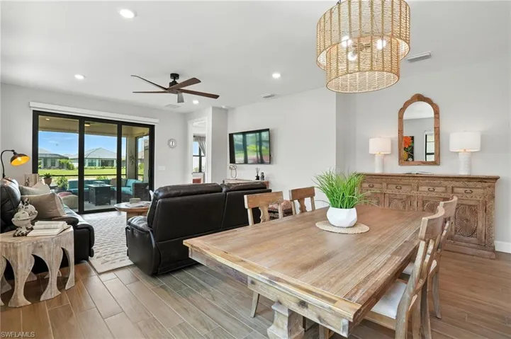 Dining room with light wood finished floors, recessed lighting, ceiling fan, and a chandelier