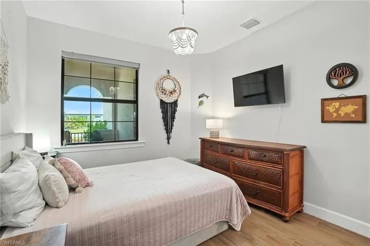 Bedroom featuring light wood-type flooring and a chandelier