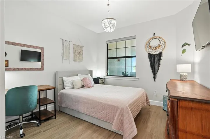 Bedroom featuring wood finished floors and a chandelier