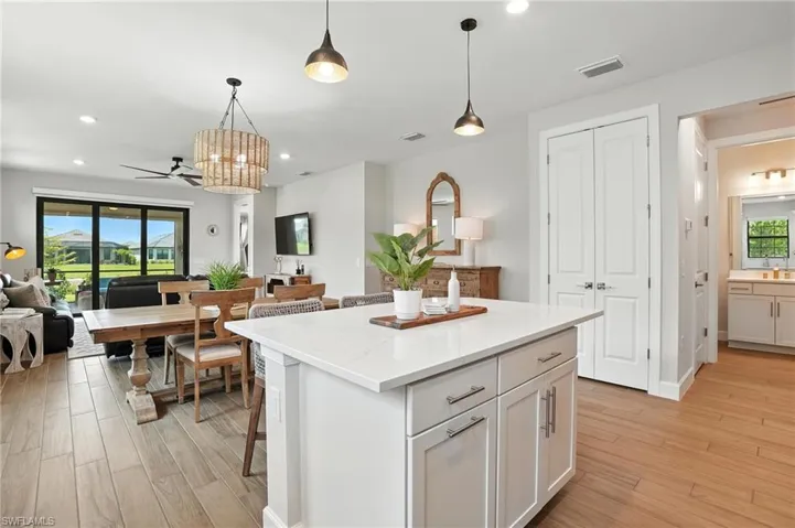 Kitchen featuring open floor plan, a center island, light wood finished floors, decorative light fixtures, and recessed lighting