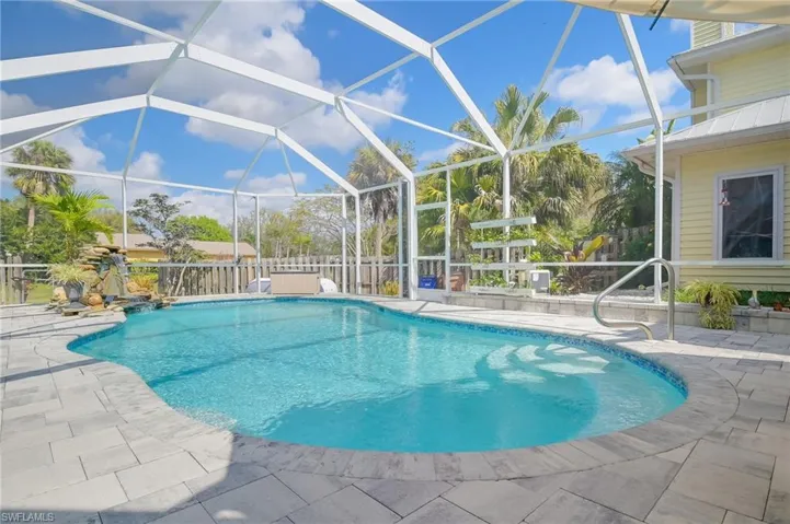 View of the pool facing the side of the home.  Big pool cage adds more volume to the outdoor area.