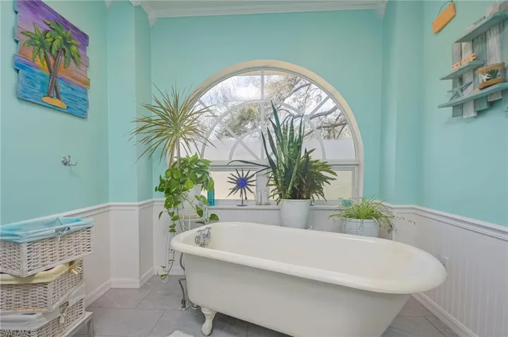 Cozy master bath with Wainscoting surrounding a claw foot tub perfect to relax and unwind after a long day.
