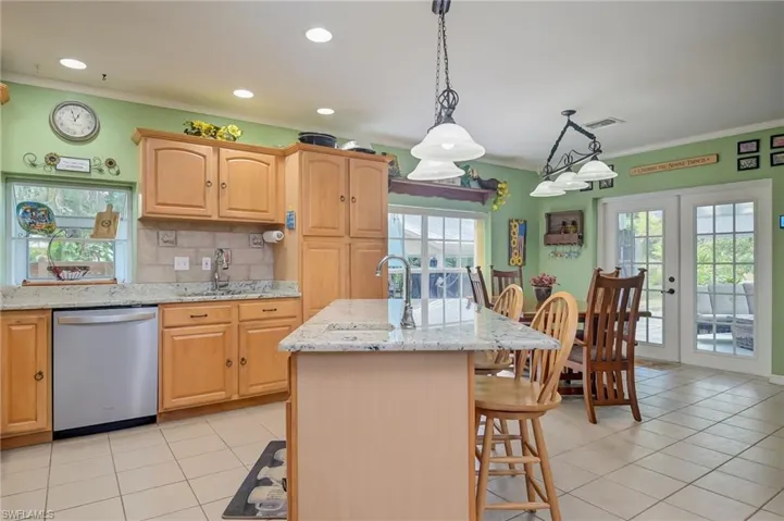 Open eat in kitchen overlooking the lanai.  Granite countertops with lots of space and stainless appliances.  Two sinks including one on the island.  Tile backsplash and window box perfect for fresh herbs.