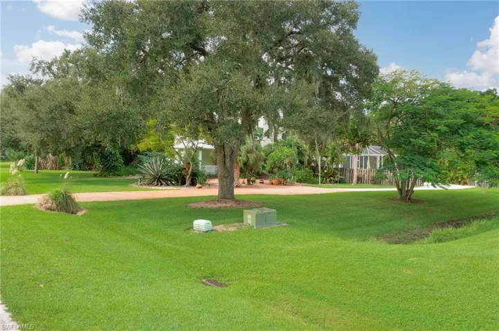 Side view facing property.  Lots of majestic oaks and other native trees provide lots of shade on sunny days and cool down the property surrounded by a lush lawn.