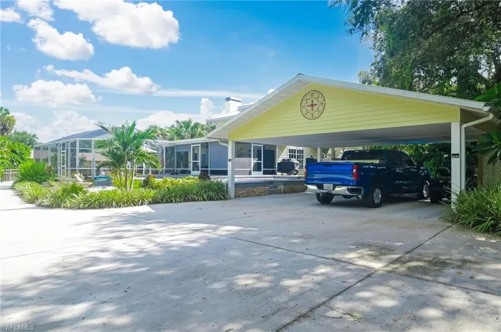 Carport with circular driveway easily holds 2 cars and a golf cart.