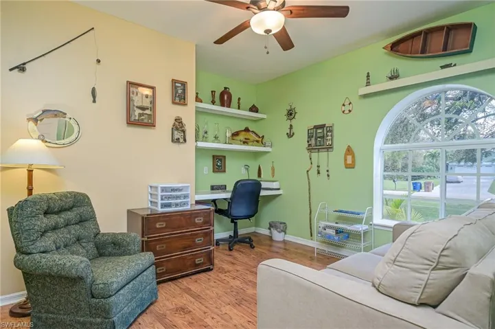 Guest room ith wood flooring, built in shelving and pretty domed windows.