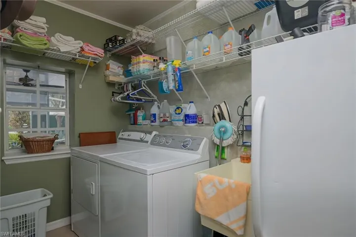 Laundry room with washer/dryer, laundry tub and stand up freezer.  Lots of shelves for storage.