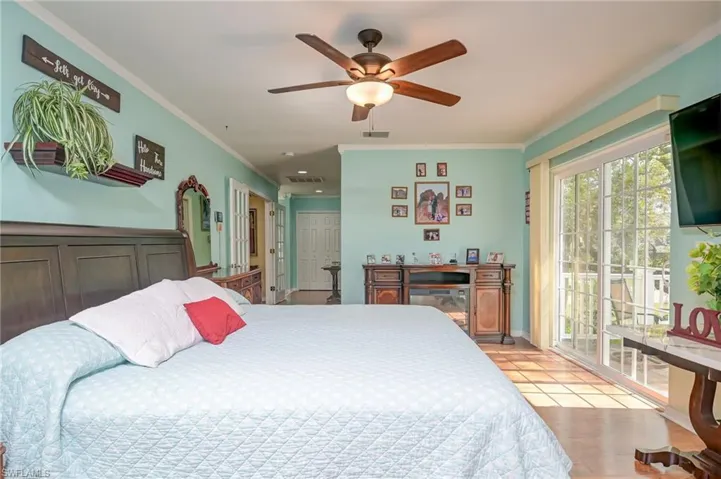 View of the master bedroom with double french doors and french sliders leading to the balcony.
