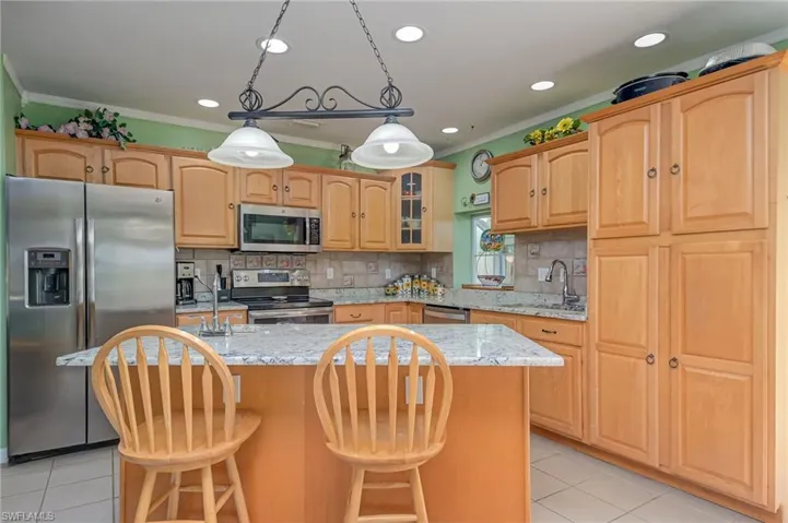 Breakfast bar with sink, stainless appliances and lots of cabinet space.