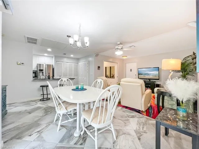 Dining area with ceiling fan with notable chandelier