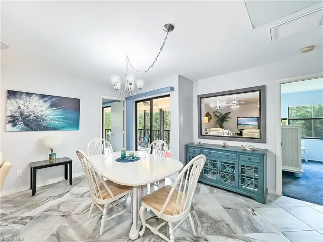 Dining space with ceiling fan with notable chandelier and a wealth of natural light