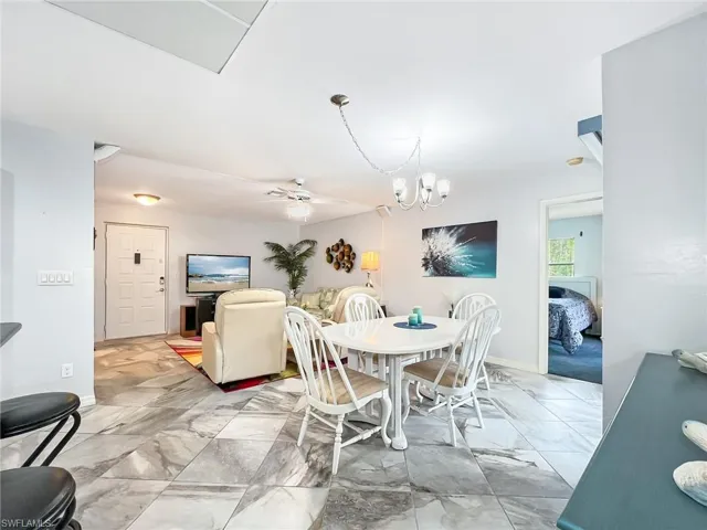 Dining space with ceiling fan with notable chandelier